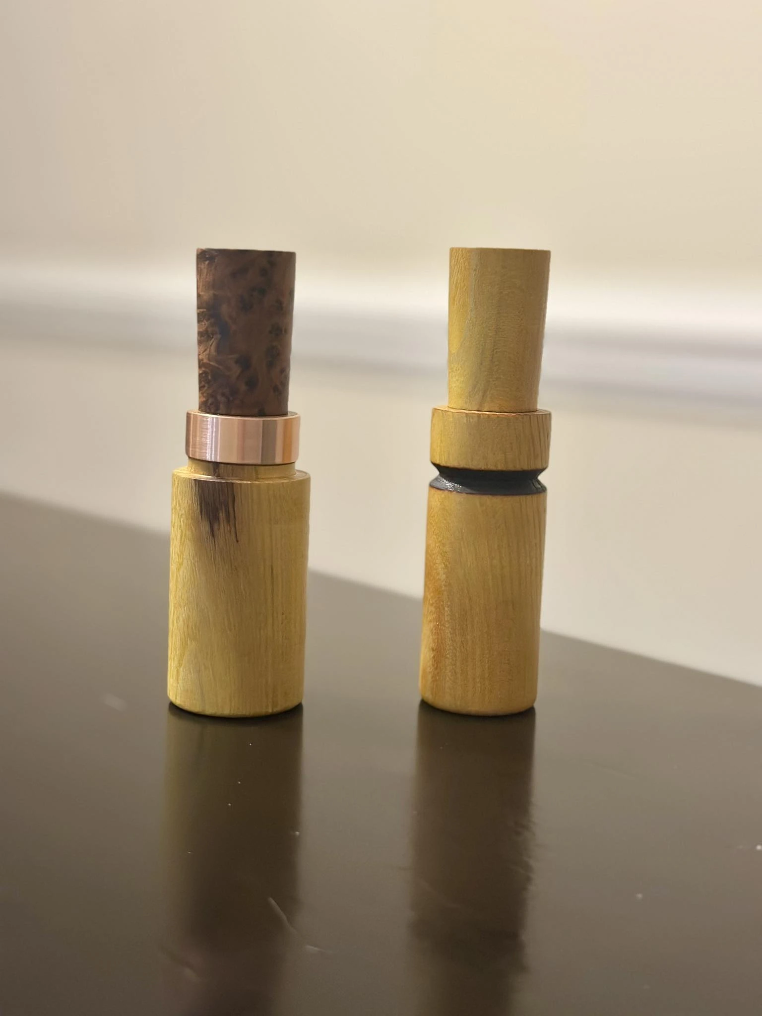 Three hand turned wood game calls with copper accent bands.