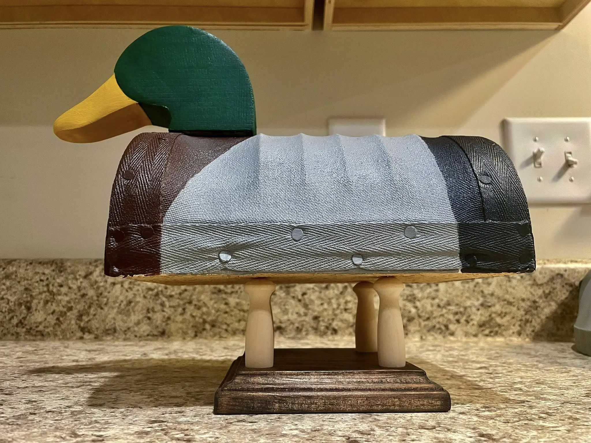 Detailed side view of a handmade mallard decoy.
