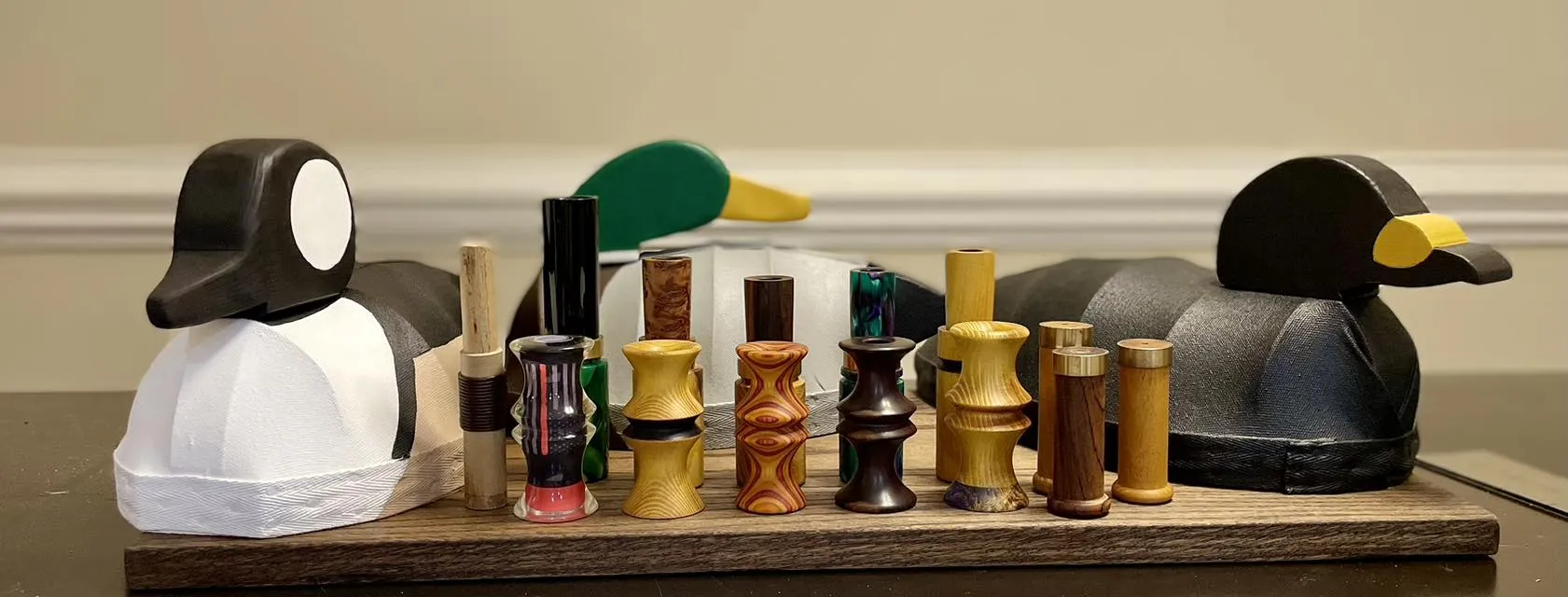 Collection of handmade decoys and game calls on a wooden display board.